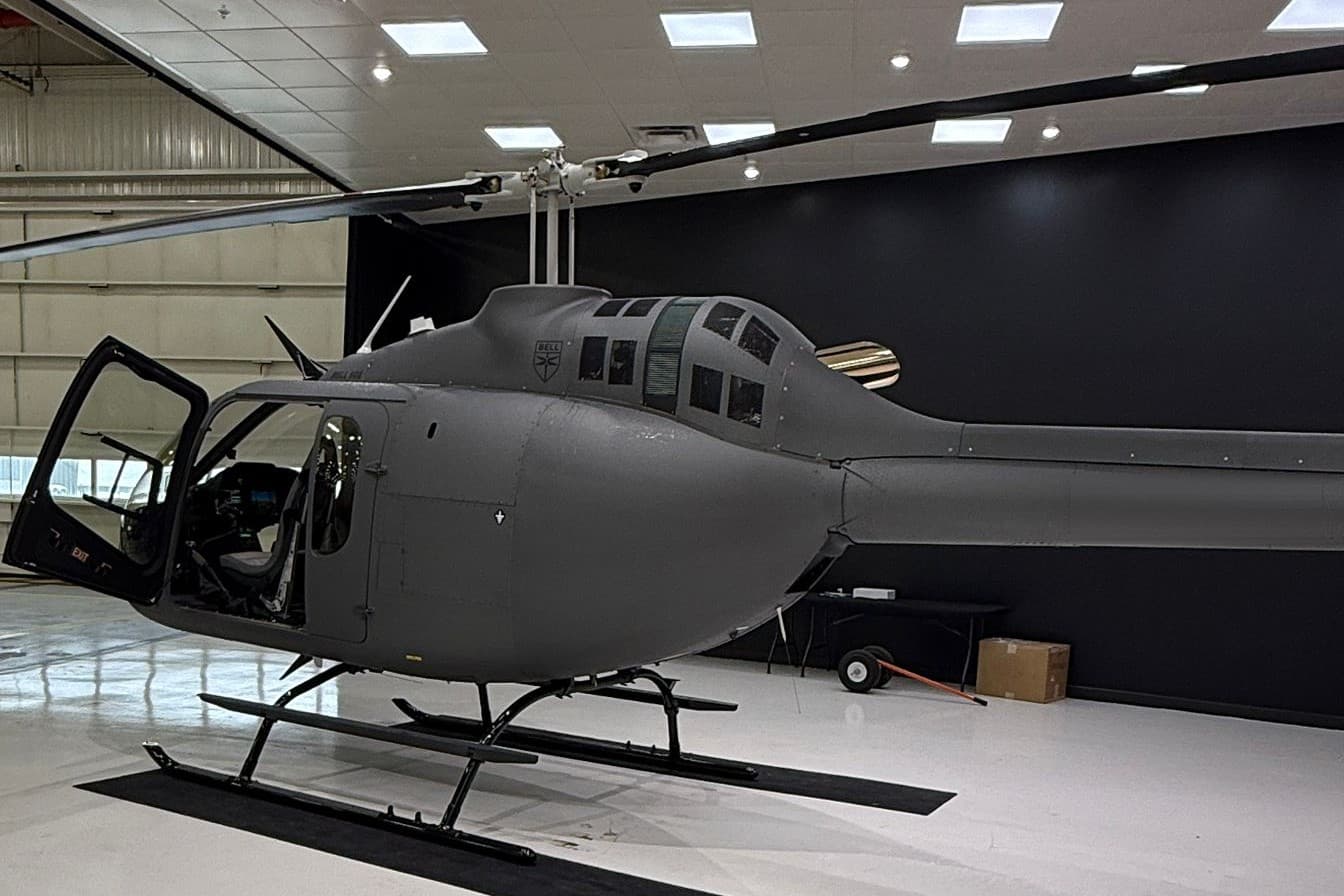Helicóptero en el hangar, con la puerta de cabina abierta
